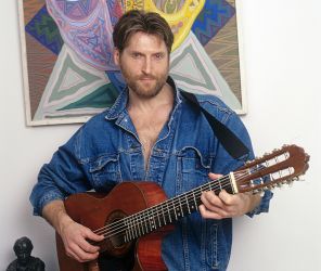 На фото: российский актер Никита Джигурда со своей гитарой на фоне картины. 2002