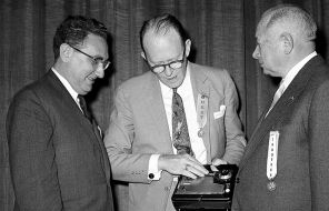 На фото: слева направо: доктор Генри Киссинджер из Гарвардского университета; доктор Уиллард Ф. Либби, Комиссия по атомной энергии, и Дэвид Сарнофф, президент RCA, 1957